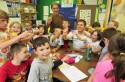 Tupper Lake Mayor, Mickey Desmarais, Wild Center Naturalist, Rob Carr, and second graders from Tupper Lake get ready to eat salt n'vinegar flavored crickets and mexican spice flavored larvae in preparation for BuzzzFest on Saturday, July 2nd.